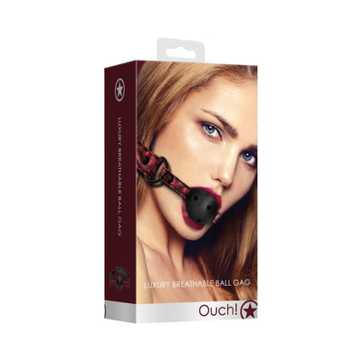 Packaging of breathable luxury ball gag in burgundy with a model wearing the black ball gag and red strap.