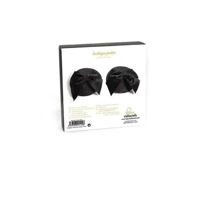 Black glittery burlesque pasties with satin bow accents in white packaging.