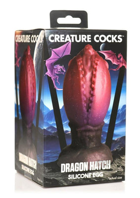 Packaging box of Creature Cocks Dragon Hatch large silicone egg with dragon-themed design and purple dragons on a fantasy landscape background.