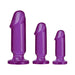 Three purple translucent anal plugs in small, medium, and large sizes with flat bases for stability.