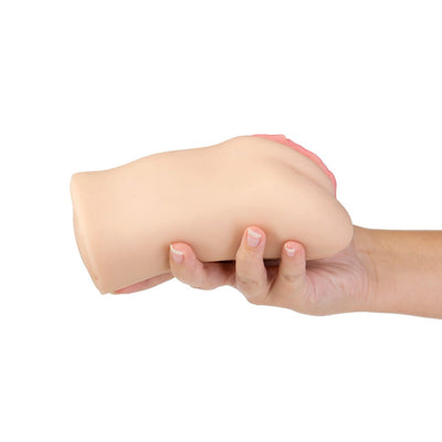 Hand holding a compact, flesh-toned soft stroker with a pink vaginal opening detail against a white background.