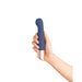 Hand holding a sleek blue silicone personal massager with a curved tip and rose gold base.