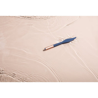 Blue silicone feather-shaped vibrator with rose gold handle floating in water, showcasing its waterproof design.