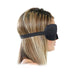 Side view of a woman wearing a black neoprene padded sensory deprivation mask with an adjustable elastic strap.