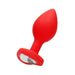 Red silicone butt plug with a tapered shape and a clear diamond detail at the flared base.