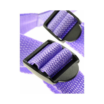 Close-up of adjustable purple nylon strap with black plastic buckle for a strap-on harness.