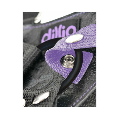 Close-up of Dillio Pur strap-on harness featuring purple nylon strap, black silicone O-ring, and metal snap button detail.