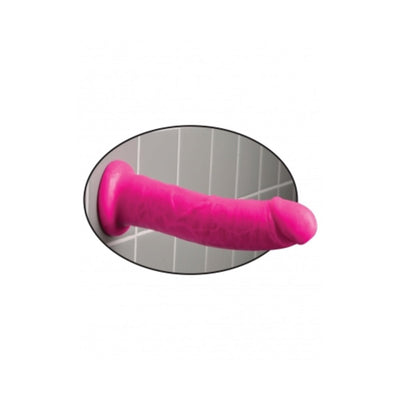 Pink Dillio dildo with suction cup base attached to tiled wall for hands-free use.