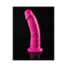 Pink flexible dildo with suction cup base standing upright on reflective black surface.