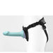 Black adjustable strap-on harness with light blue silicone attachment on white mannequin side view.