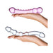 Two hands holding a set of two textured glass dildos, one pink and one clear, showcasing their smooth and curved designs.