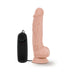 Realistic flesh-toned vibrating toy with suction base and black wired remote control on white background
