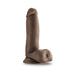 Chocolate-colored realistic dildo with balls and suction cup base standing upright on white background.