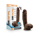 Chocolate-colored 8.5-inch self-lubricating dildo with balls and suction cup base next to its branded packaging box.