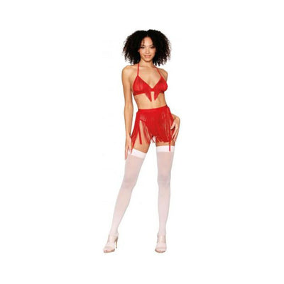 Model wearing a ruby red chainette fringe bralette and matching high-waist fringe skirt with white thigh-high stockings and nude heels.