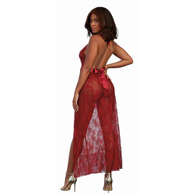 Woman wearing a sheer red lace halter gown with an open back and satin tie, paired with gold high heels.