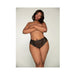 Plus size model wearing black lace tanga panty with open-crotch and elastic open back detail against neutral background.