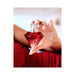 Hand holding a red diamond-shaped Eye of Love Matchmaker pheromone perfume bottle with clear cap against a soft background.