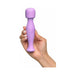 Hand holding a compact purple silicone body massager with a power button on the handle.