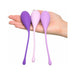 Hand holding three silicone kegel trainers in varying shades of purple, designed for pelvic muscle strengthening.