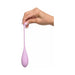 Hand holding a soft pink silicone kegel trainer with a tapered, elongated shape and flexible tail loop.
