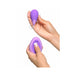 Hands holding a purple silicone kegel exerciser and matching remote control with a white background.