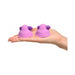 Hand holding two small pink and purple silicone vibrating nipple stimulators with compact design.