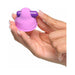 Hand holding a small pink silicone vibrating nipple stimulator with purple vibration bar on top.