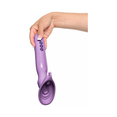 Hand holding a purple vibrating roto suction device with three control buttons on the handle against a white background.