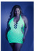 Plus size model wearing neon green glow net halter dress with open back and intricate cutout patterns under blue lighting.