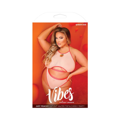 Plus size model wearing peach cut-out halter top and cheeky panty lingerie set against an orange background.