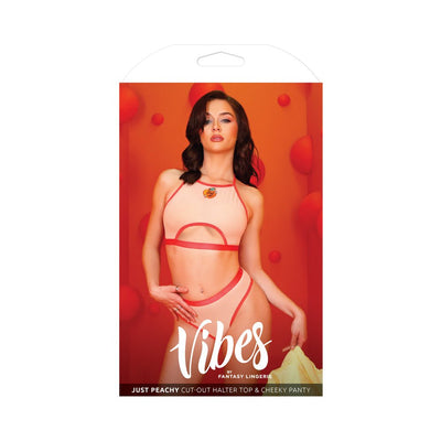 Peach-colored cut-out halter top and cheeky panty set with red trim worn by model against orange background.