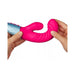 Hands holding a flexible pink dual-density liquid silicone rabbit vibrator with textured curves and a silver handle.
