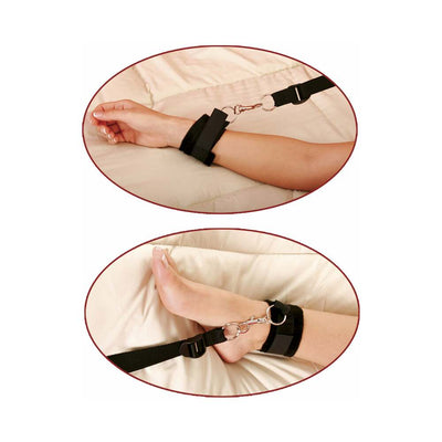 Close-up of black nylon wrist and ankle cuffs secured with metal clips on a bed restraint system.