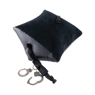 Black inflatable wedge pillow with attached nylon strap and metal handcuffs for secure positioning and restraint.