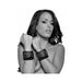 Black faux fur-lined leather cuffs with metal buckles and chain restraint worn on model's wrists.