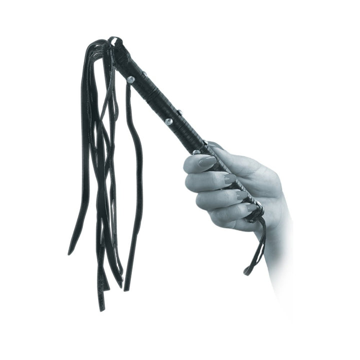 Hand holding a black leather flogger whip with multiple tails and studded handle.