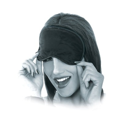 Woman smiling while adjusting a black satin love mask over her eyes, part of a beginner's bondage kit.