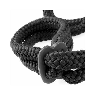 Close-up of black braided silk rope with plastic cinch for adjustable bondage cuffs.