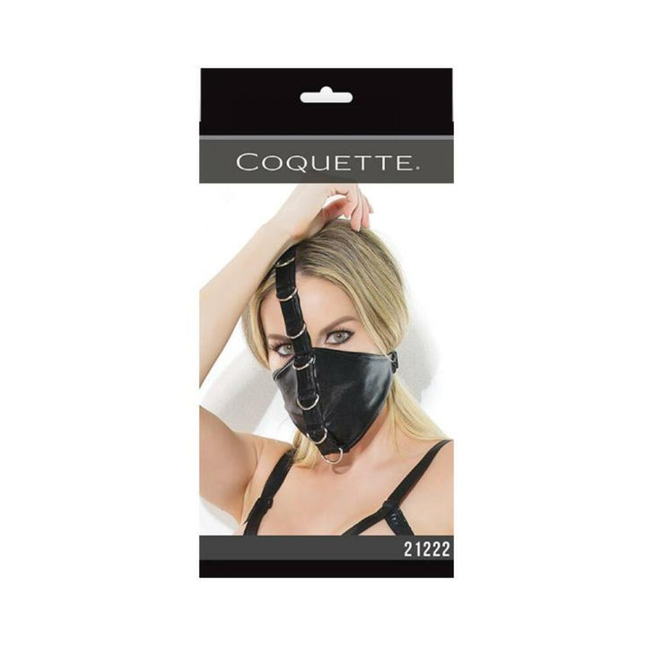 Black fetish mask with metal D-ring accents and adjustable straps, worn by a model with blonde hair.
