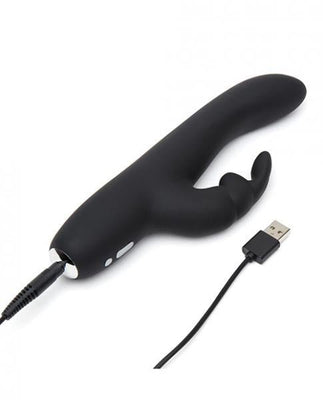 Black slimline rabbit vibrator with curved shaft and clitoral stimulator, shown with USB charging cable connected.