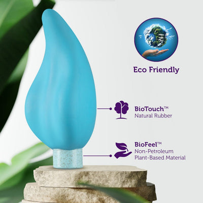 Blue eco-friendly vibrator made from natural rubber and plant-based materials, displayed on stone with green leaves background.