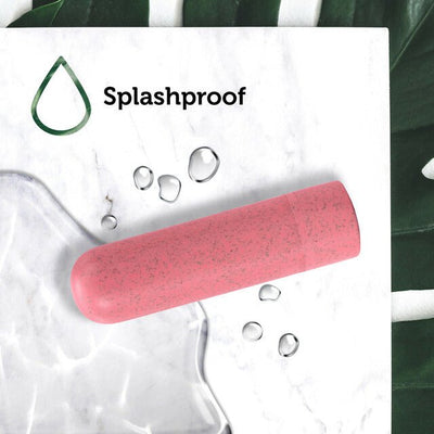 Coral-colored Blush Gaia Eco Rechargeable Bullet on marble surface with water droplets highlighting splashproof feature.