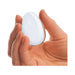 Hand holding a smooth, teardrop-shaped clear glass yoni egg for pelvic wellness exercises.