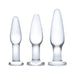 Three-piece set of clear frosted glass anal training plugs in small, medium, and large sizes with flared bases.