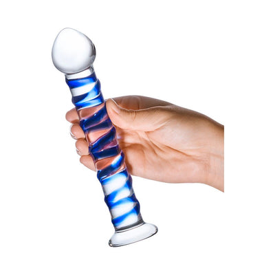 Hand holding a clear glass dildo with a blue spiral ridge and bulbous head on a white background.