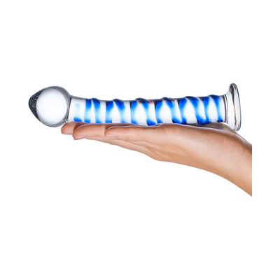 Hand holding a blue and clear spiral glass dildo with a bulbous head and flat base on a white background.