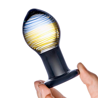 Hand holding a Glas Galileo Glass Butt Plug with a bulbous, striped blue and yellow design and a black base.