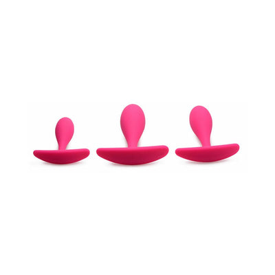 Set of three magenta silicone anal trainers in small, medium, and large sizes with curved bases for comfort.