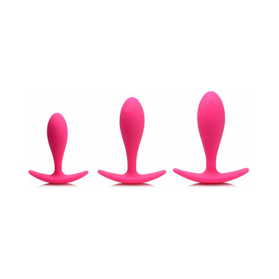 Set of three magenta silicone anal trainers in small, medium, and large sizes with curved bases for comfort.